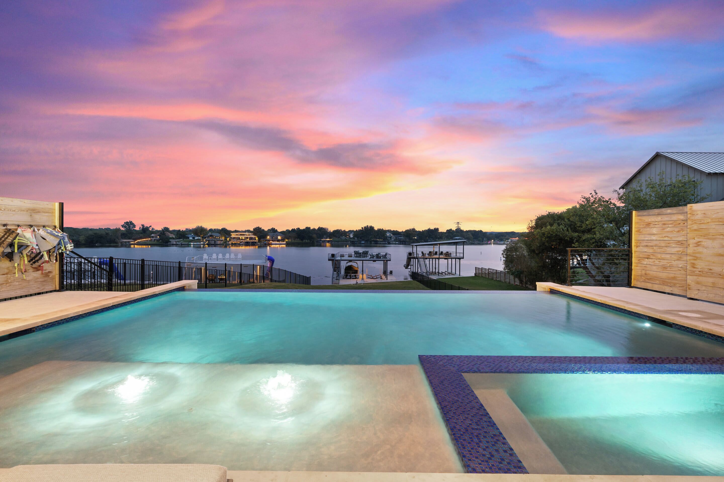 A swimming pool with a view of a body of water and a dock in the background.