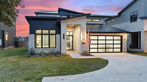 A modern two-story house with a garage, a driveway, and a well-maintained lawn.
