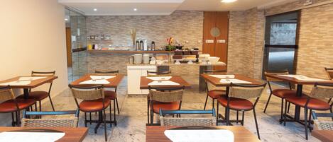 A hotel dining area with tables, chairs, and a buffet counter.