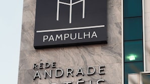 En hotellskylt med namnen ”PAMPULHA” och ”REDE ANDRADE HOTÉIS” på en byggnadsfasad.