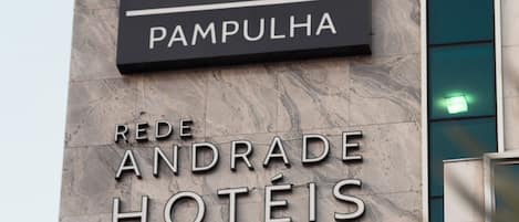 Un letrero de hotel con el nombre "PAMPULHA" y "REDE ANDRADE HOTÉIS" en la fachada de un edificio.