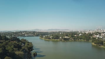 Un río con un paisaje urbano al fondo, rodeado de vegetación.