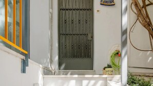 A set of white marble stairs leading to a door with a metal gate. - Canto-Home Alongside The Acropolis (Athina)