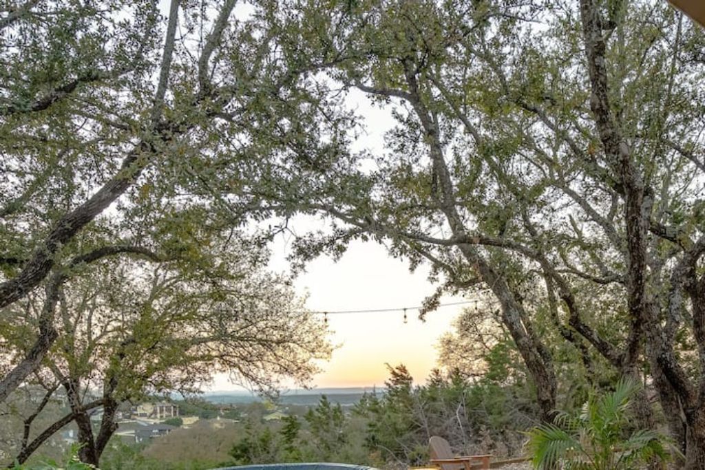 A view of a tree-lined area with a clear sky and a distant landscape.