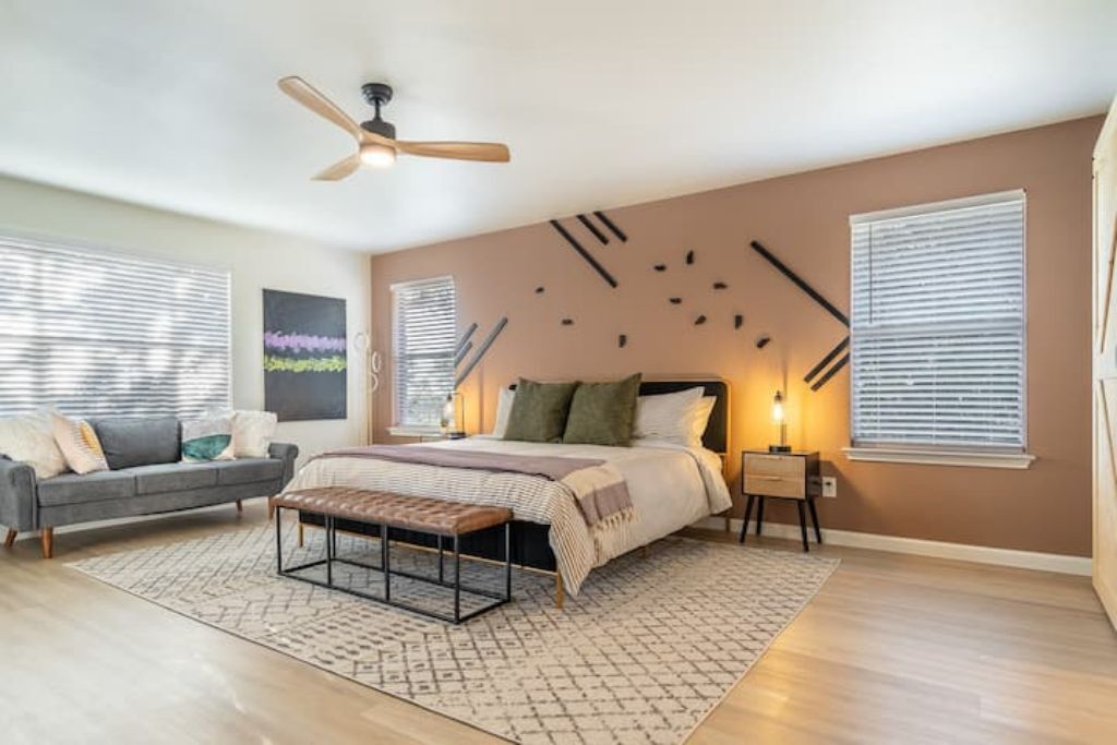 Un dormitorio con cama, mesita de noche y ventilador de techo.