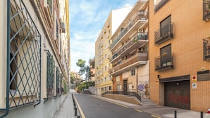 A narrow urban street with multi-story buildings, balconies, and a gated entrance. - LooP Las Ventas - Adults Only (Madrid)