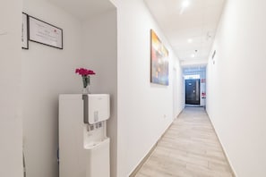 Experience the hotel's commitment to excellence with a water dispenser and framed recognition on display, set against a vibrant abstract art piece.