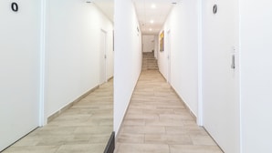 A clean, modern hallway with light wood flooring and white walls, leading to a staircase. - LooP Las Ventas - Adults Only (Madrid)