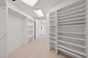Een gang met witte schapunits en een deur naar een andere kamer.