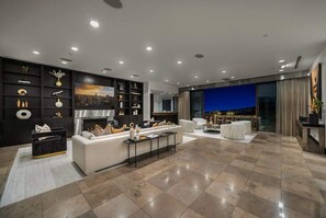 Un salon moderne avec une cheminée, un canapé, une table basse et un coin repas offrant une vue agréable.