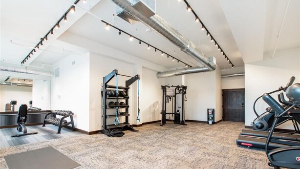 A gym with exercise equipment, a standing desk, and a treadmill. - 110- Brand New Studio near Glacier Park (Columbia Falls)