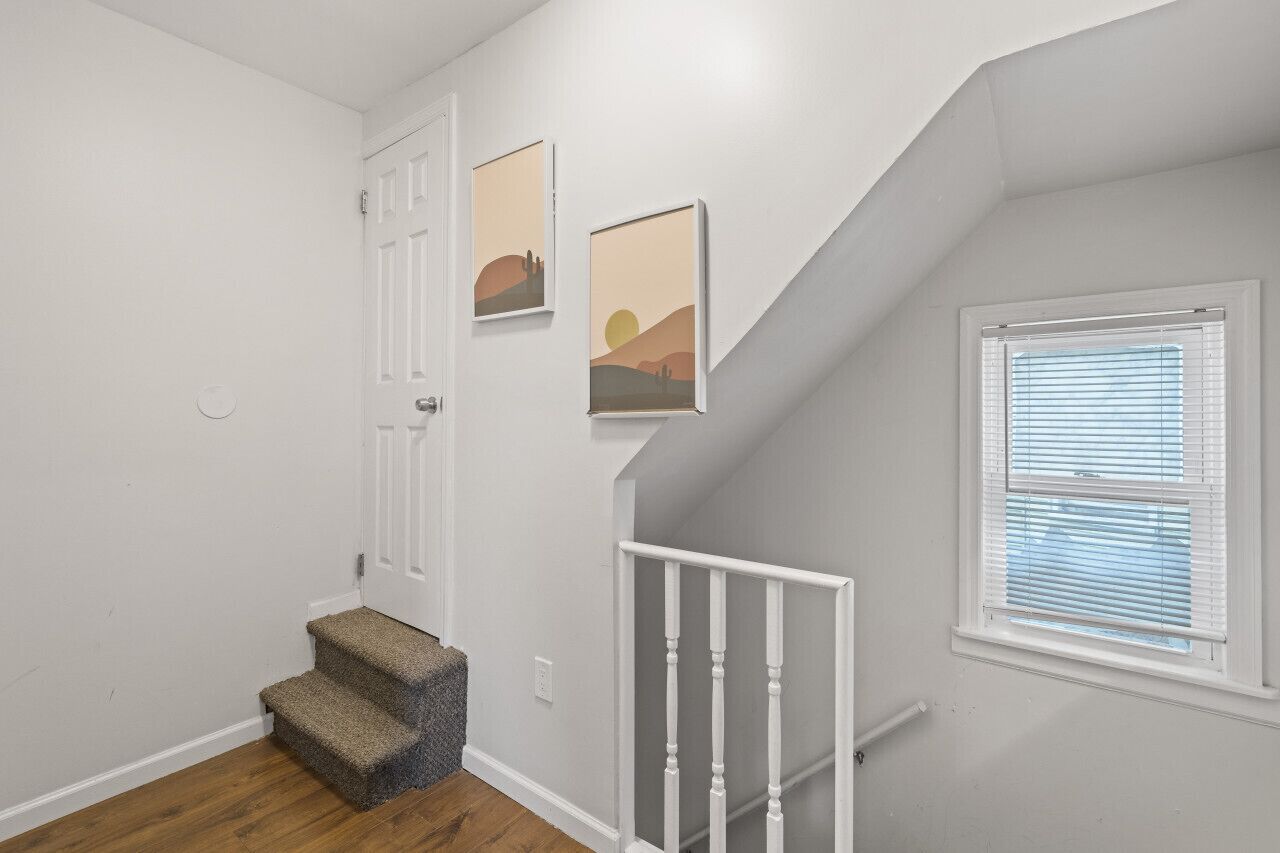 A staircase with white railings and a carpeted landing.