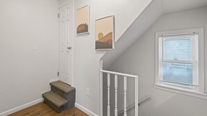 A staircase with white railings and a carpeted landing.