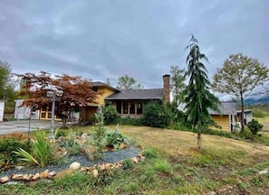 Two-story house with a charming porch and beautifully maintained garden.