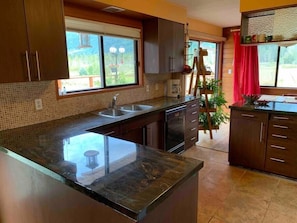 Enjoy cooking in this well-equipped kitchen with a double sink, coffee maker, and wooden ladder for easy access to storage.