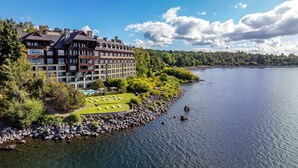 Een groot hotel met meerdere verdiepingen, een zwembad en uitzicht op een meer.