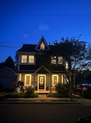 Stunning two-story house with a central entrance and beautifully manicured lawn.