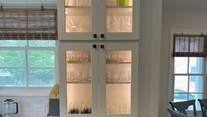 A kitchen with a built-in cabinet with glass doors, a double oven, and a window with blinds. - Walk or bike to everything Lewes has to offer! (Lewes)