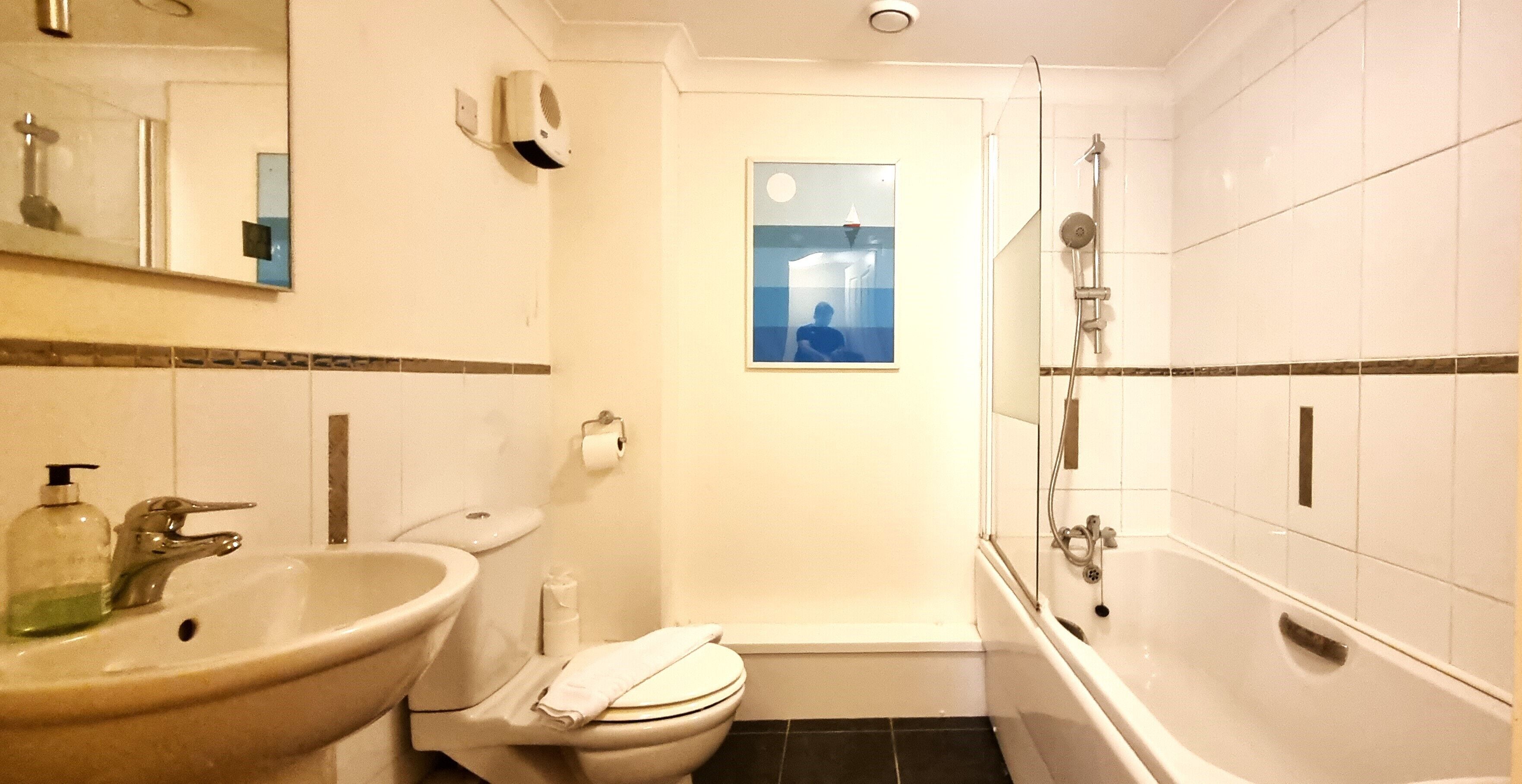 A bathroom with a sink, toilet, and bathtub.