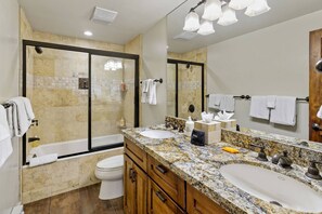 A modern bathroom with a large sink, a bathtub, and a shower.