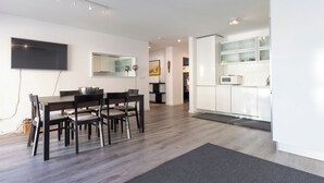 A modern kitchen with white cabinets, a microwave, and a large window.