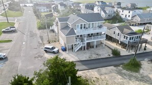 A coastal residential area with detached houses featuring balconies and a sandy beach.