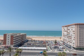 A coastal hotel with multiple floors, a parking lot, and a view of the beach and ocean. - Cortadura Beach Apartment (Cádiz)