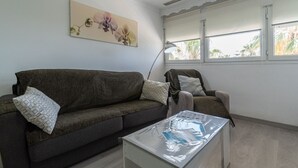 Een woonkamer met een donkerbruine bank, een witte salontafel en een lamp.