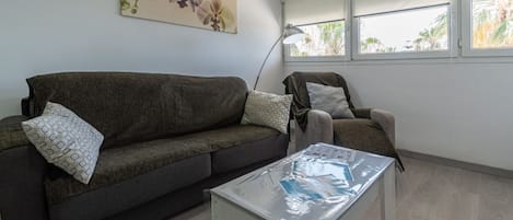 A living room with a dark brown sofa, a white coffee table, and a lamp.