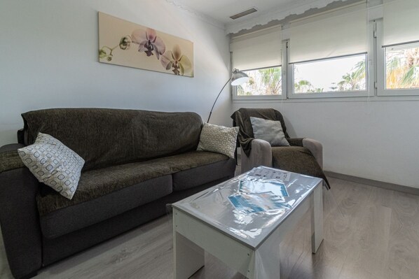 A living room with a dark brown sofa, a white coffee table, and a lamp.