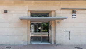 Een gebouw ingang met een glazen deur en een bord waarop nummer 19 staat.