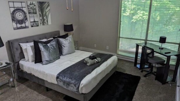 A bedroom with a bed, a desk, and a window with blinds. - Stylish 2BD/2BA in Arlington | Convenient & Clean! (Arlington)