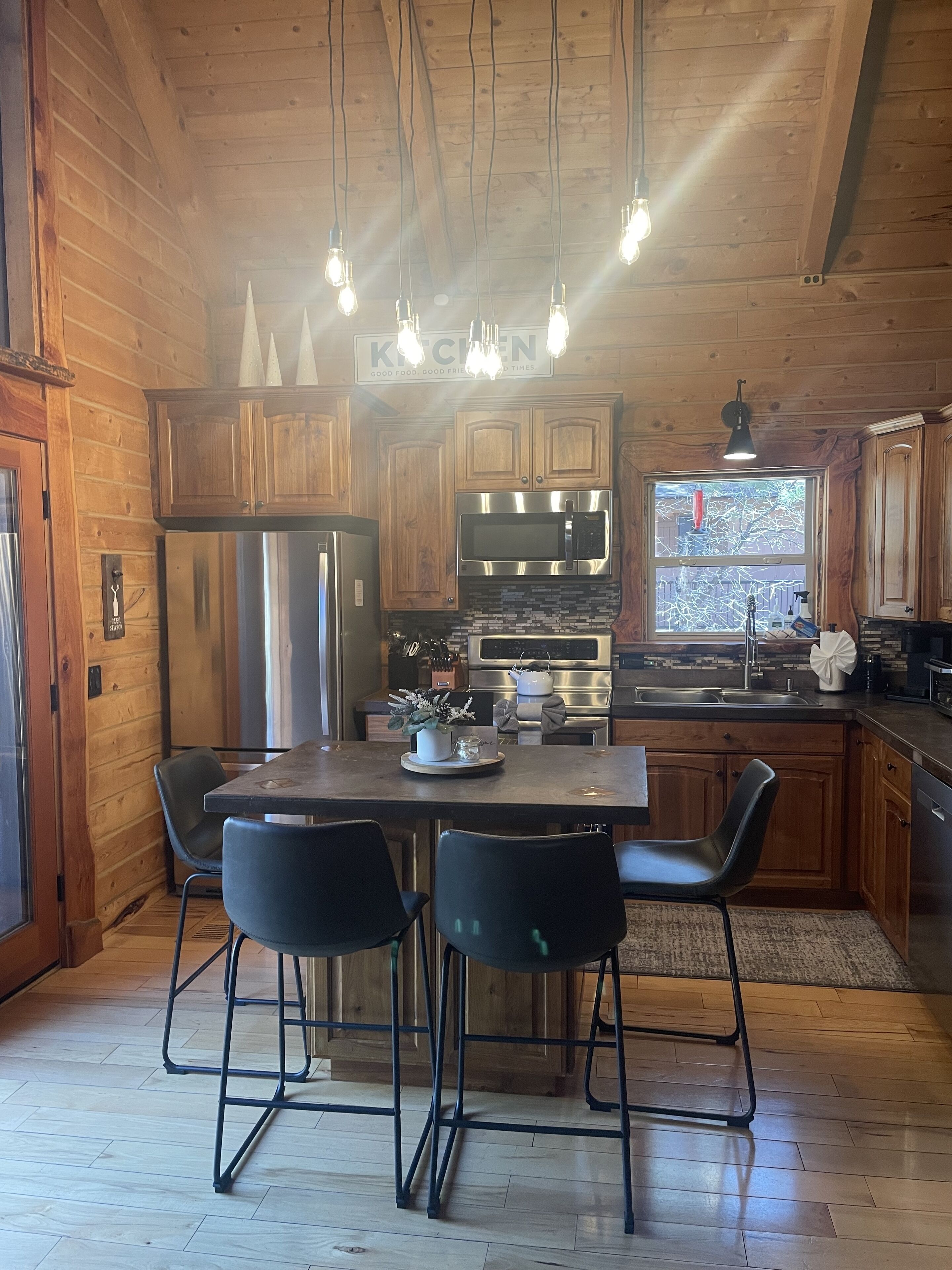 Een houten keuken in cottage-stijl met een eettafel, stoelen en moderne apparatuur.