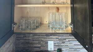 Ein Schrank mit mehreren Einlegebögen, der klare Gläser und Tumbler beherbergt.