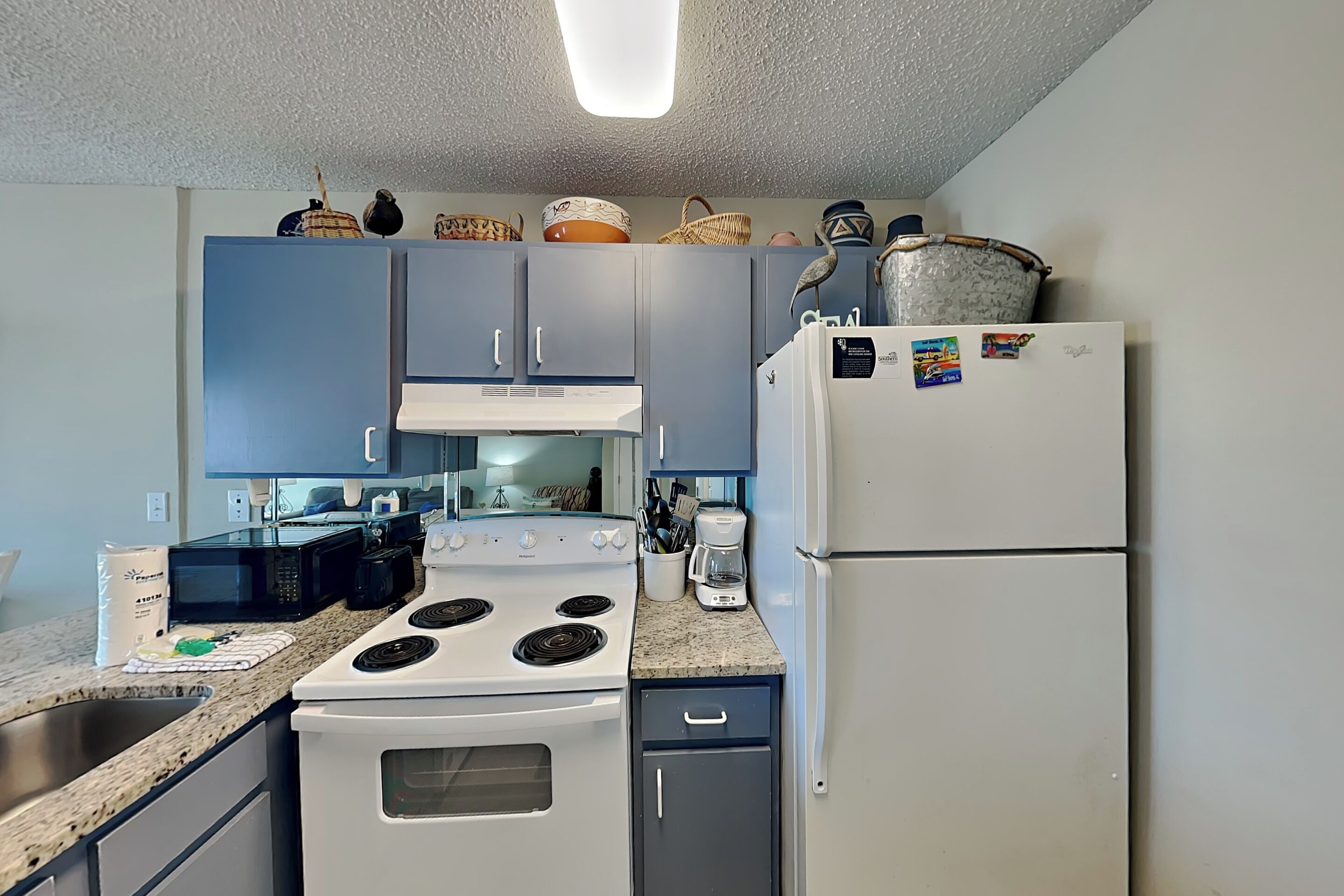 A kitchen with a stove, microwave, refrigerator, and cabinets.