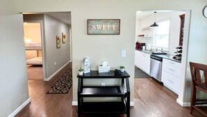 Una cocina moderna con gabinetes blancos, encimera negra y una estación de café.