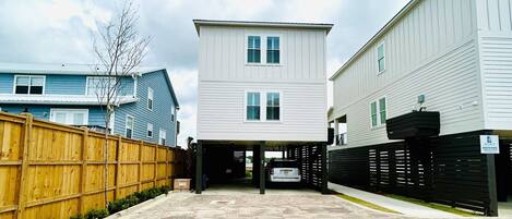A residential area with a two-story house, a garage, and a wooden fence.