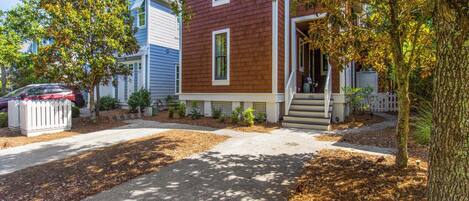 A two-story house with a front porch, a mailbox, and a driveway.
