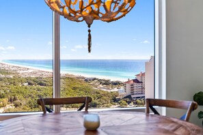 Enjoy a meal with a view of the ocean and coastline from this room's large window.