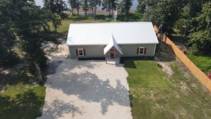 A two-story house with a gravel driveway and a small front porch.