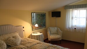 A bedroom with a bed, a chair, a lamp, a painting, and a television on the wall. - ROMANTIC PENTHOUSE 7 BEDS (Case Alte)