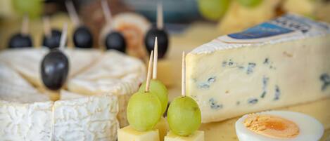 A cheese board with various cheeses, grapes, and a boiled egg.