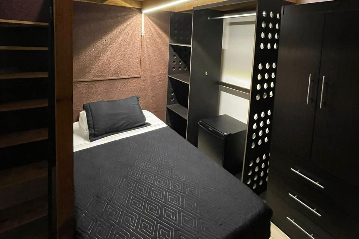 Ein kleines Zimmer mit Etagenbett, Schreibtisch und Kleiderschrank.