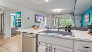 A modern kitchen with a white countertop, stainless steel sink, and a dish rack. - Waterfront Cozy Cove Retreat - LOTO Escape, Remodeled Comfort, Close to the Fun (Lake Ozark)