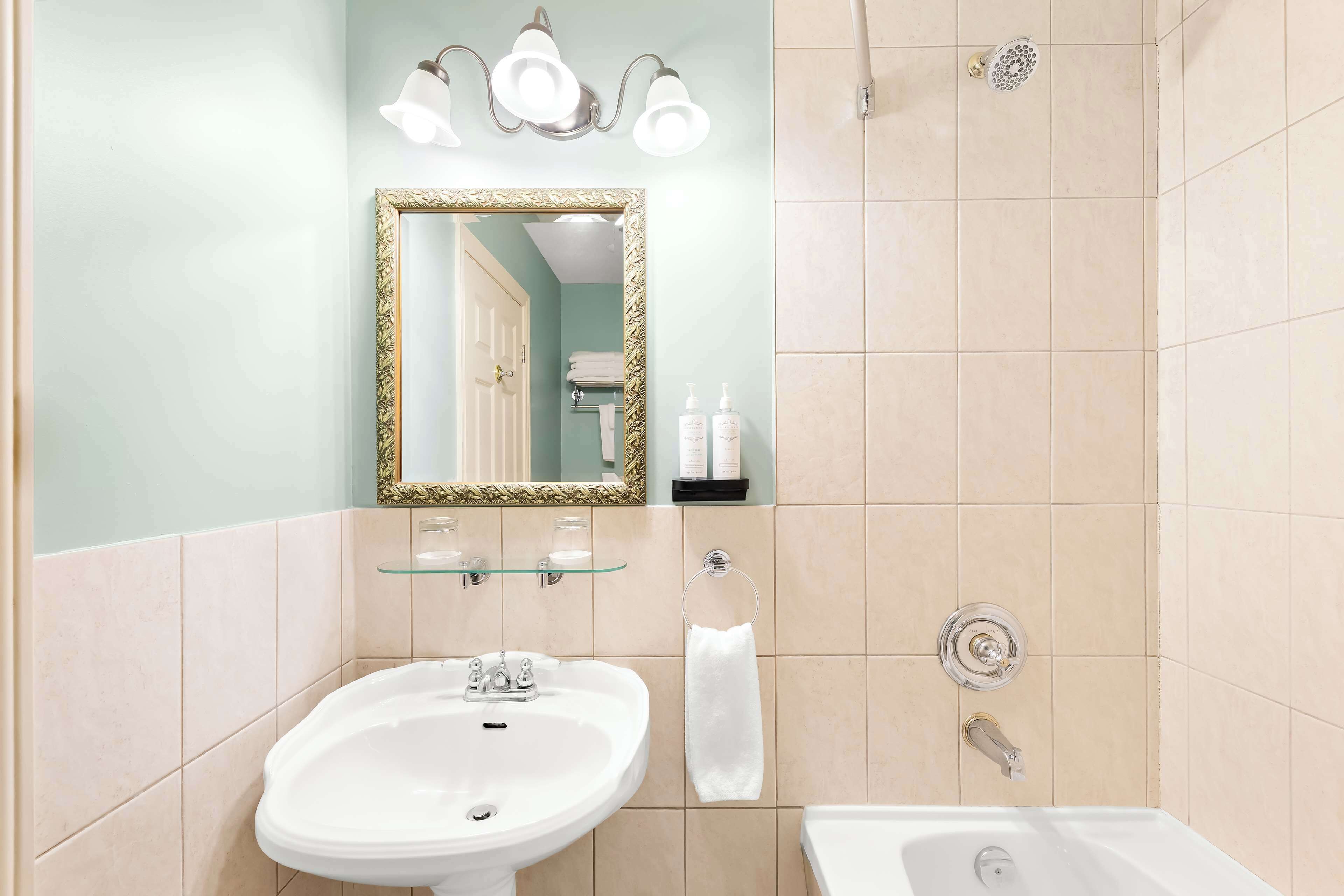 Ein Badezimmer mit Waschbecken, Spiegel und Dusche.