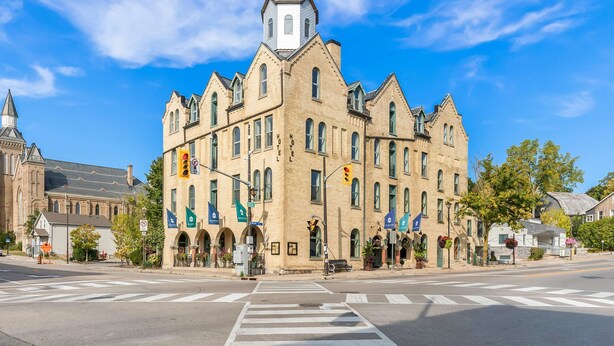 A historic hotel with a prominent tower, large windows, and a classic architectural style. - The Arlington Hotel, Bw Signature Collection (Brant)