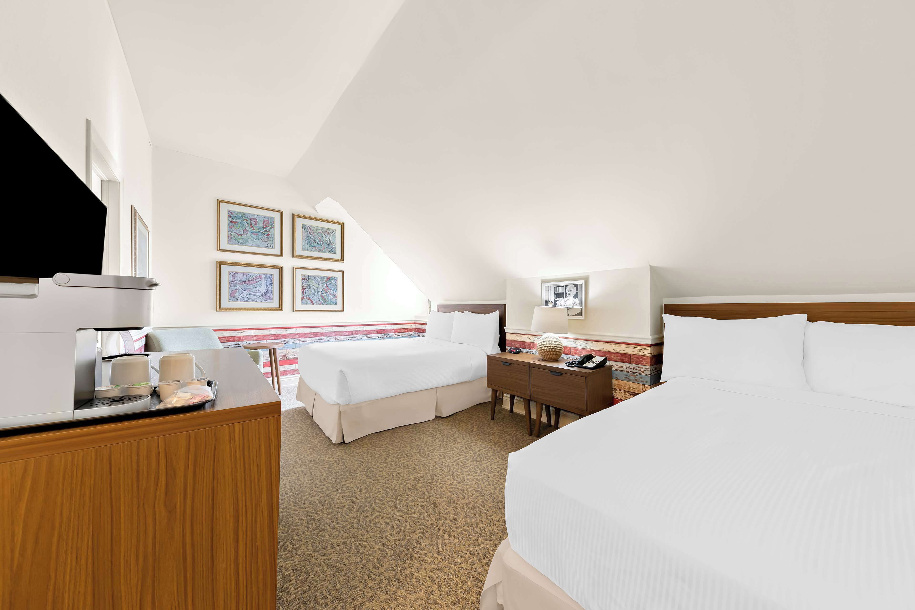 Une chambre d’hôtel équipée d’un lit, d’un bureau, d’une chaise et d’une machine à café.