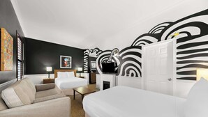 A hotel room with a modern design, featuring a sofa, a bed, a desk, and a television. - The Arlington Hotel, Bw Signature Collection (Brant)