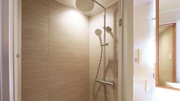Une douche moderne équipée d’un pommeau de douche à main et d’un pommeau de douche fixe au plafond.