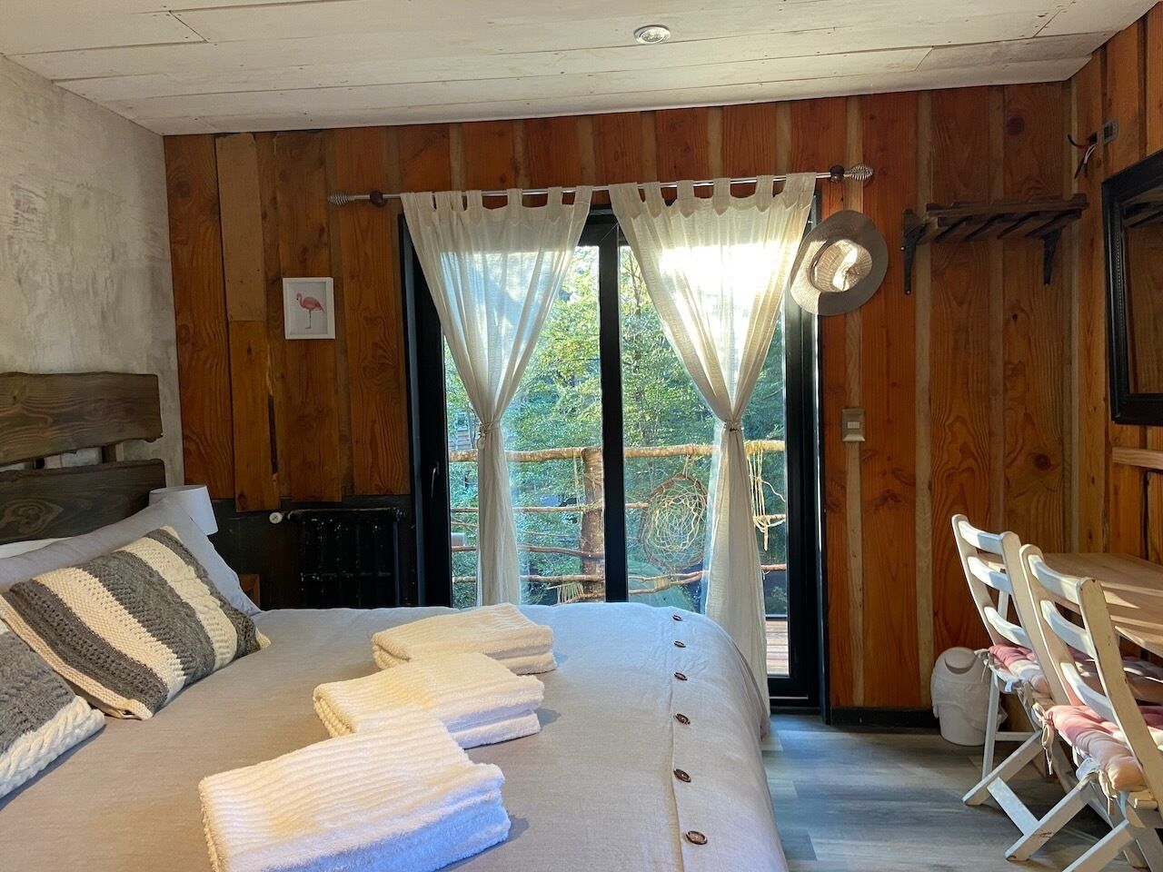 Una habitación con paneles de madera, una cama, una mesa y una silla.